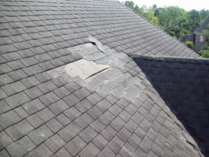 Damaged asphalt shingle roof with missing shingles, showing a clear need for repair by Castle Contracting Group in Cincinnati, OH.