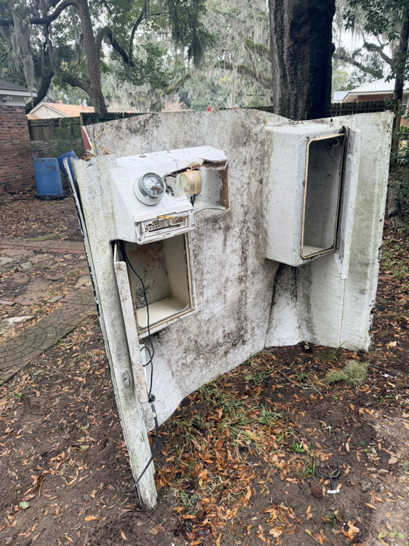 A large, damaged boat part lying in a yard, awaiting junk removal by Won't Bash Your Trash in Savannah, GA.
