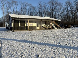 A damaged building with a large pile of demolition debris, ready for junk removal by Limitless Hauling & Junk Removal in Troy, OH.
