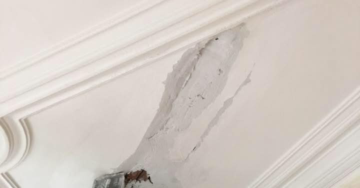 A damaged ceiling with peeling plaster in need of repair by Eric Aulbach Plastering in Saint Louis, MO.