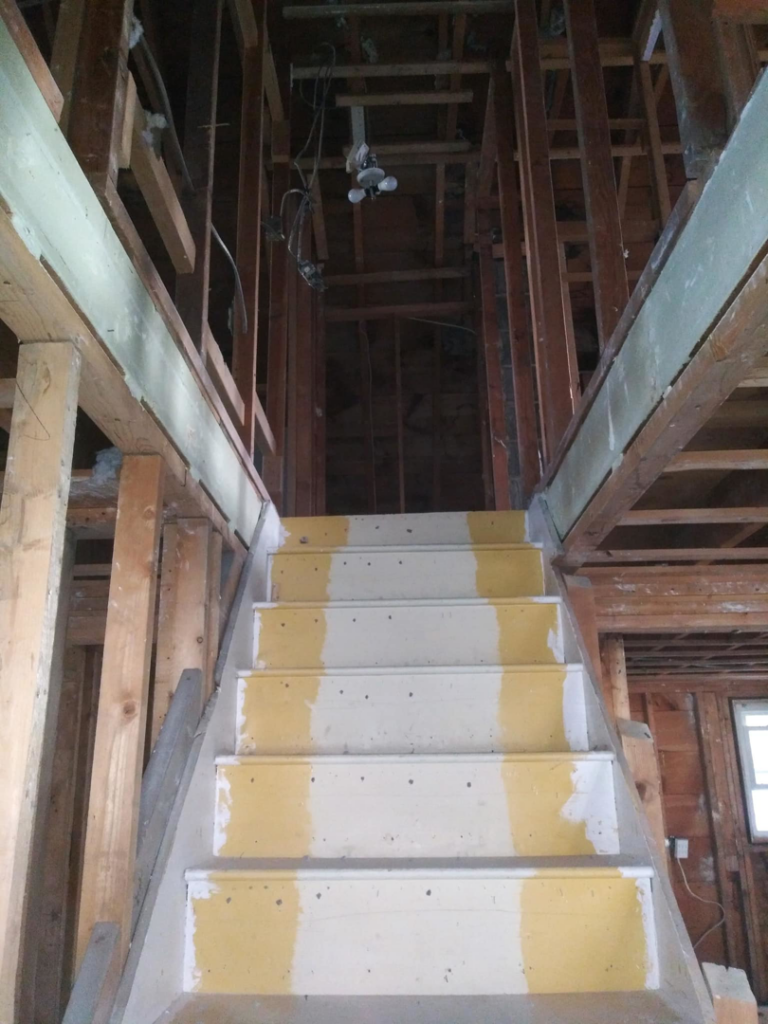 A damaged and cluttered room with caution tape, ready for cleanup and restoration by J-BO Enterprises, Inc in Wilmington, MA.
