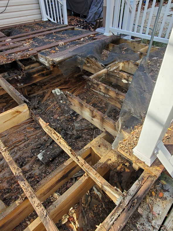 A damaged wooden deck with exposed joists, showing a deck repair project by Handyman Hal in Wilmington, DE.