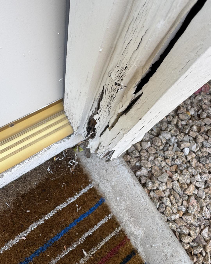 Close-up of a severely damaged door frame needing repair by Eddie of all trades in Peoria, AZ