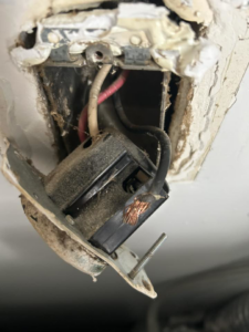 A close-up of a damaged electrical outlet with exposed wiring, ready for repair by Katzenstein llc handyman in Council Bluffs, IA.