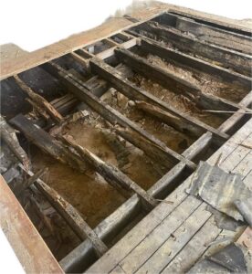 Severely damaged wooden floor joists and subfloor requiring repair by Appalachian Foundation Services in Roanoke, VA.