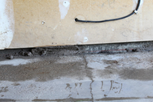 Close-up of a damaged foundation or wall base with exposed material, ready for repair by American Mud Jack INC in Arvada, CO.