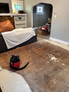 Damaged hardwood floor in a room undergoing renovation preparation, handled by NV Floors LLC in Pittsburgh, PA.