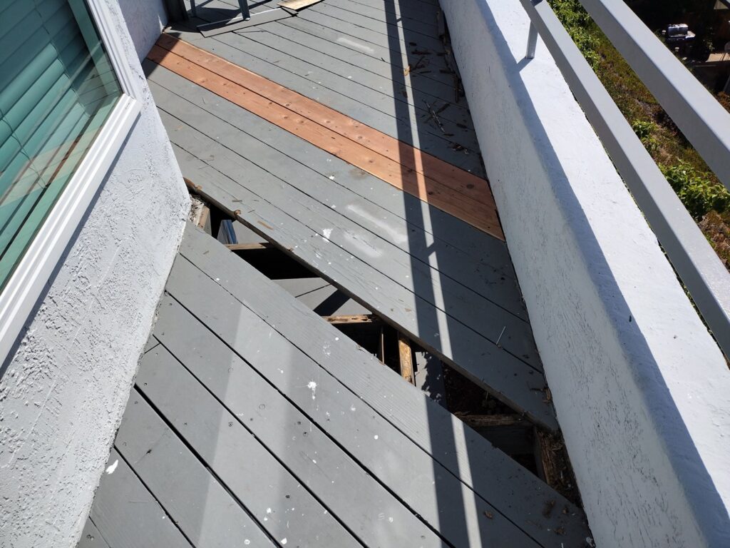 A damaged outdoor deck with broken and missing planks, indicating a need for repair services from Handyman SanDiego in San Diego, CA.