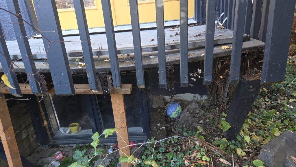 A damaged outdoor deck railing with a broken post, requiring repair by Infinity Handyman in Anchorage, AK