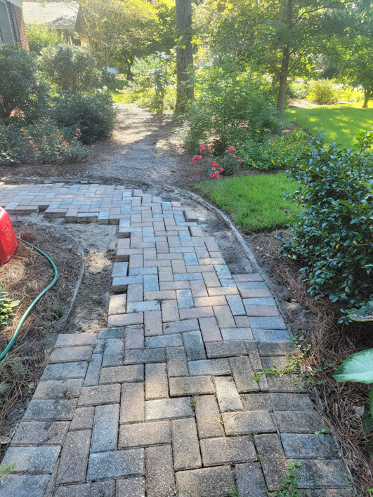 A damaged paver pathway before repair work by Keystone Design in Tallahassee, FL.
