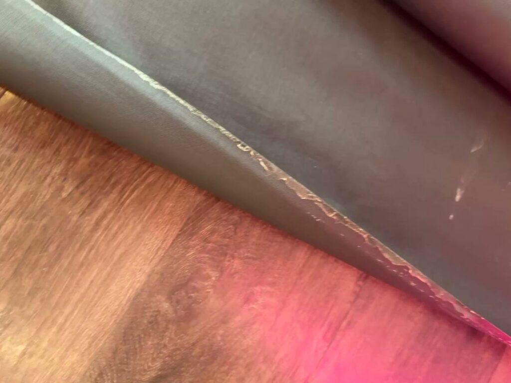 Damaged and peeling floor material on a wooden floor, indicating a floor repair project by Byrd Property Restoration, LLC in Parkersburg, WV.