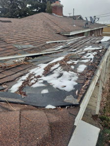 A damaged roof with missing shingles and snow, indicating a repair job by Honey Don'ts Handyman Service in Twin Falls, ID.
