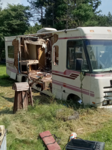 A severely damaged RV or motorhome with debris around it, ready for removal by Cox Junk & Debris Removal in Buffalo, NY.