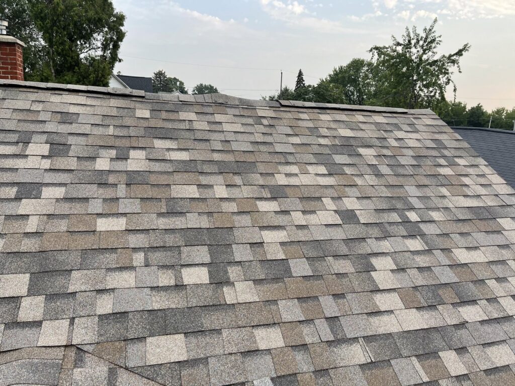 A close-up view of a damaged shingle roof in need of repair by L12 Construction LLC in Oshkosh, WI.