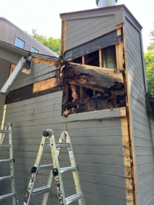 Damaged siding and exposed wood being repaired on a house exterior by Cedar Siding Repair in Centerville, OH.