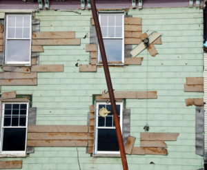 An old building with damaged siding and boarded windows, ready for exterior repair by AAA Lifetime Exterior & Remodeling LLC, Kansas City, MO.