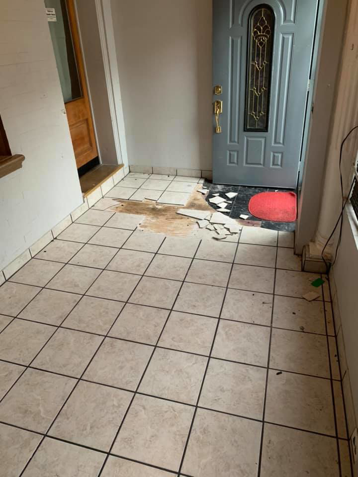 Damaged tile flooring in an entryway before renovation by Tawfiq Services LLC in Philadelphia, PA