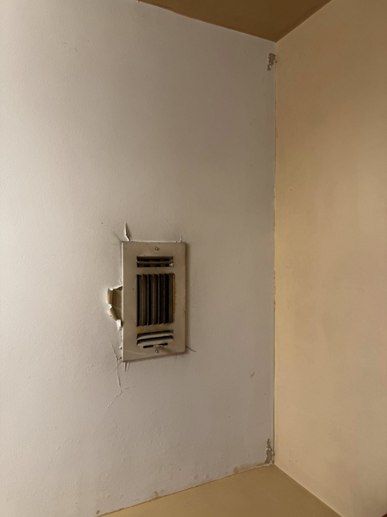 Damaged wall vent with peeling paint and drywall, showing a repair project for S & H Painting and Drywall LLC in Montgomery, AL.