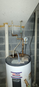A damaged water heater with corroded plumbing connections, ready for service by Ray's Property Services in Johnson City, TN