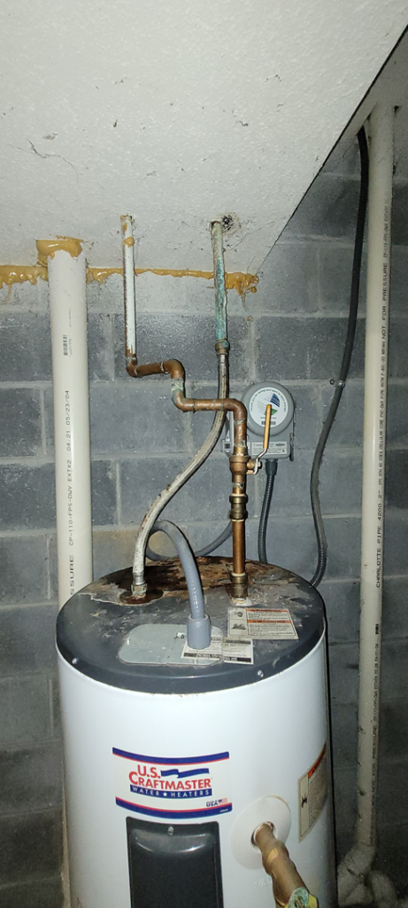 A damaged water heater with corroded plumbing connections, ready for service by Ray's Property Services in Johnson City, TN