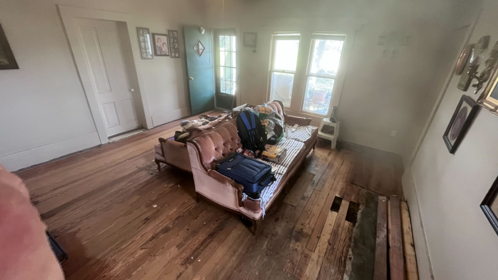 An interior room showing damaged wood flooring requiring repair or replacement, a service offered by HW Handyman Services in Springfield, MO.