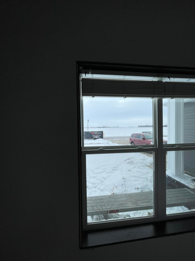 Handyman repairing damaged wood and insulation on a structure by Next Level Builders, Inc. in Grand Forks, ND.