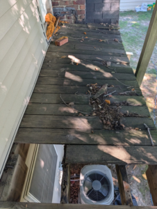 Close-up of a damaged wooden deck needing repair, showing an AC unit below, by Handyman Service in Lafayette, IN.