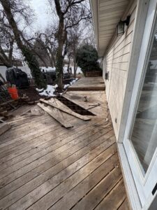 A damaged wooden deck with missing planks, indicating a repair project for Joe's Handyman Solutions in Ogden, UT.