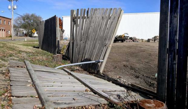 A severely damaged wooden fence requiring repair or replacement by A/M Fence in Norman, OK