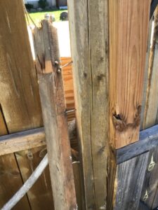 An exterior view of a damaged wooden fence, indicating a need for repair by Advance Construction Builders, LLC in Milwaukee, WI.