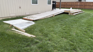 A damaged wooden ramp and cracked concrete pad, indicating a repair project by HW Handyman Services in Springfield, MO.