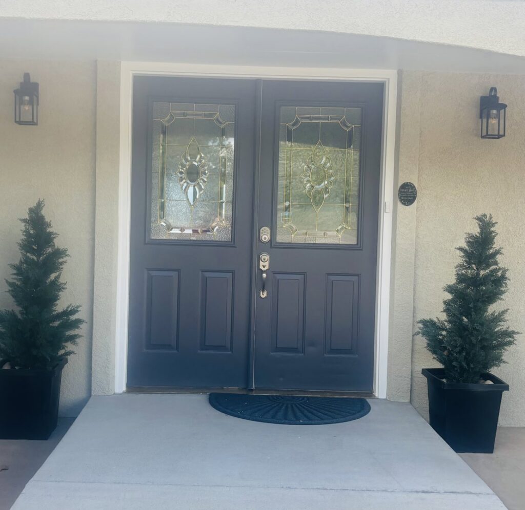Newly installed dark blue double front doors with decorative glass by Greg Unseth Painting & Exteriors in Colorado Springs, CO