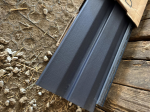 Close-up of dark grey siding panels in an open box for E.L.Y Siding Company in Buckner, MO