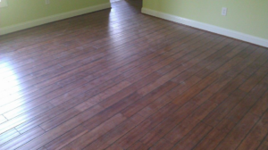 A newly installed dark hardwood floor in a room with light green walls by Cliff's Construction in Richmond, VA.