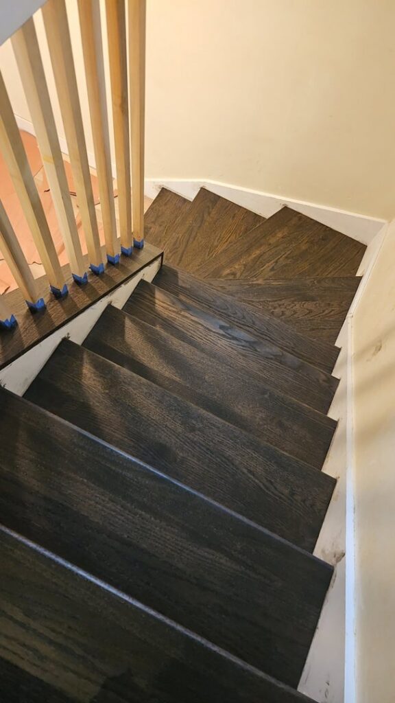 Newly installed or refinished dark stained hardwood stairs by Quick Sand Flooring & Install LLC in Millcreek, UT.