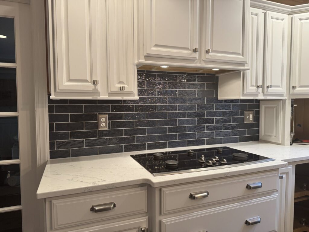 A newly installed dark subway tile kitchen backsplash above a stovetop, completed by Tile Jawn in Philadelphia, PA.