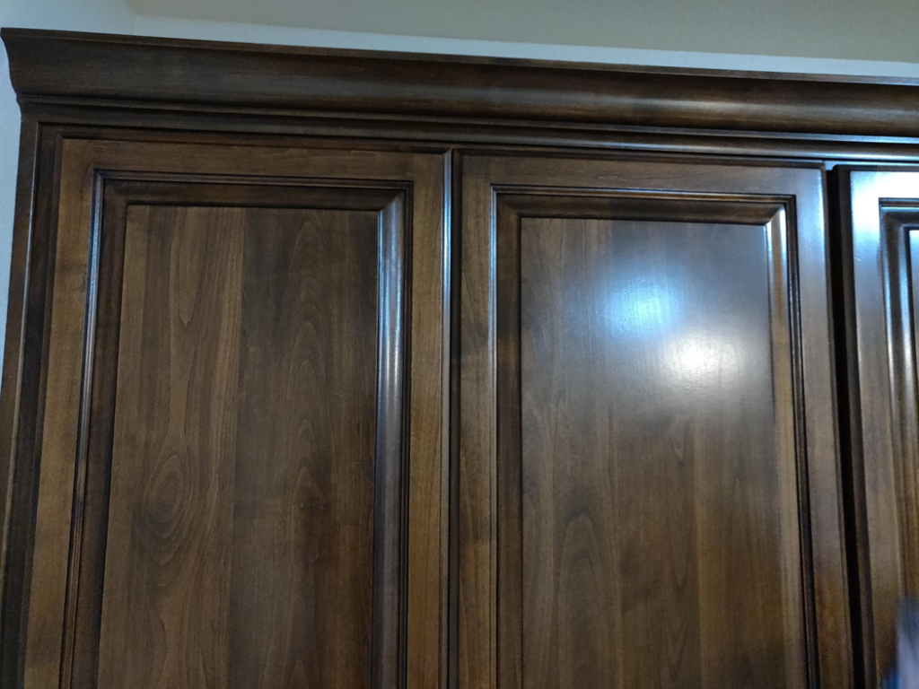 Detailed view of dark wood kitchen cabinets with elegant crown molding by Camelback Cabinets in Gilbert, AZ