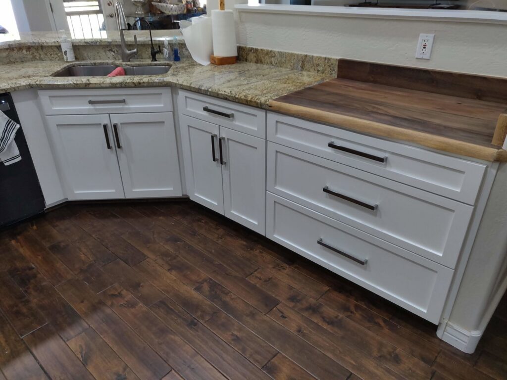 A kitchen with elegant dark wood cabinets and contrasting red walls, installed by Camelback Cabinets in Gilbert, AZ