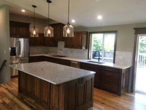 A kitchen remodel featuring dark wood cabinets, light countertops, and a central island by Myers & Myers Construction in Spokane, WA.