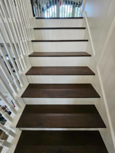 Close-up of newly installed dark wood stair treads and white risers by Amazing Spaces 21 in Orlando, FL