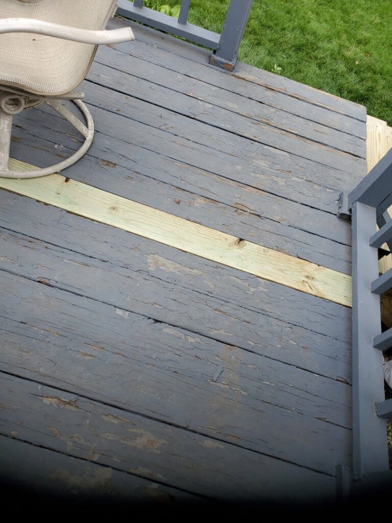 A new wooden board replacing a damaged one on an existing deck, showcasing deck repair services by Folmar's Handyman & Remodeling in Lincoln, NE.