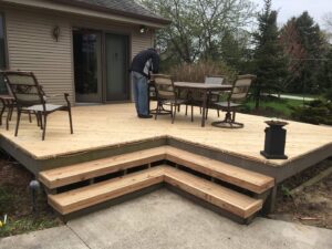 A handyman from Top Notch Contracting working on a new wooden deck in Racine, WI.
