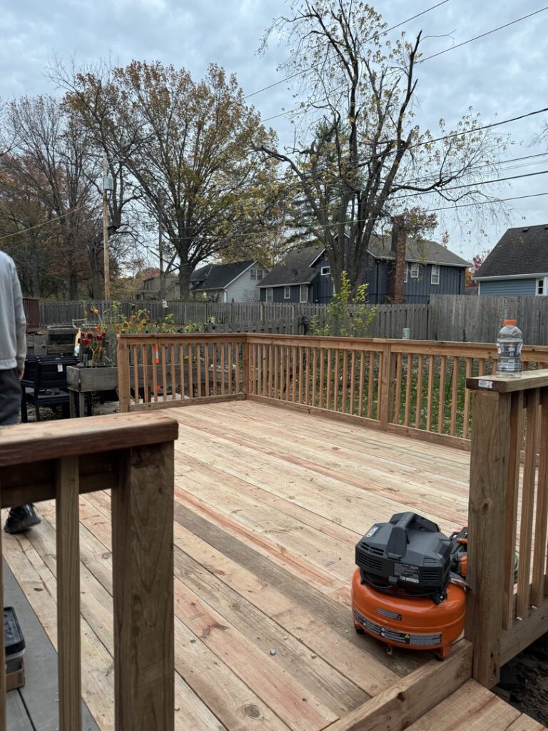 A wooden deck under construction with an air compressor on site by Gateway Home Services KC LLC in Kansas City, MO.