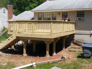 A handyman working on a wooden deck construction project in progress by Mainville Construction & Remodeling LLC in Newington, CT.