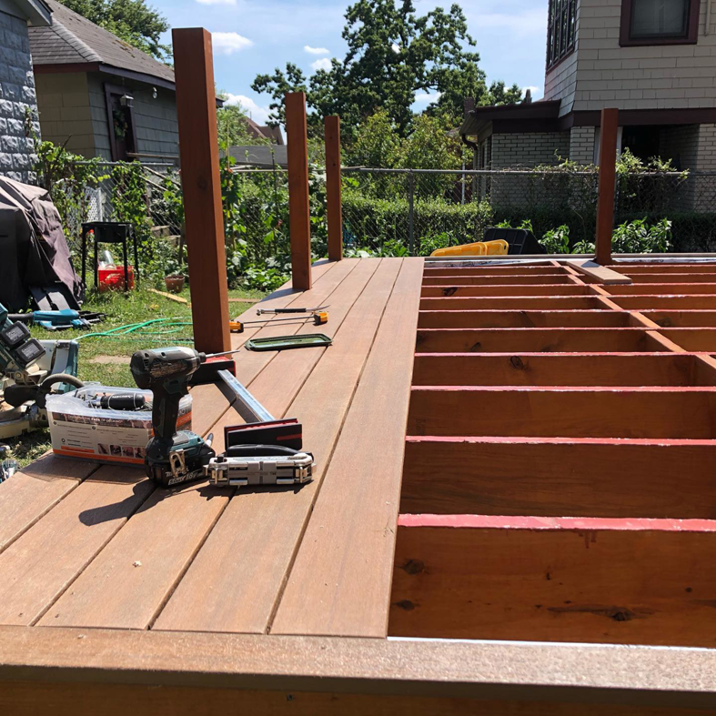 Outdoor deck construction in progress with wooden planks and tools by Surtec Remodeling Inc. in Pittsburgh, PA.