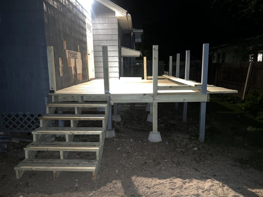 Deck construction in progress at night by TD Estimating Group LLC in Springfield, MA, showing the framework and stairs.