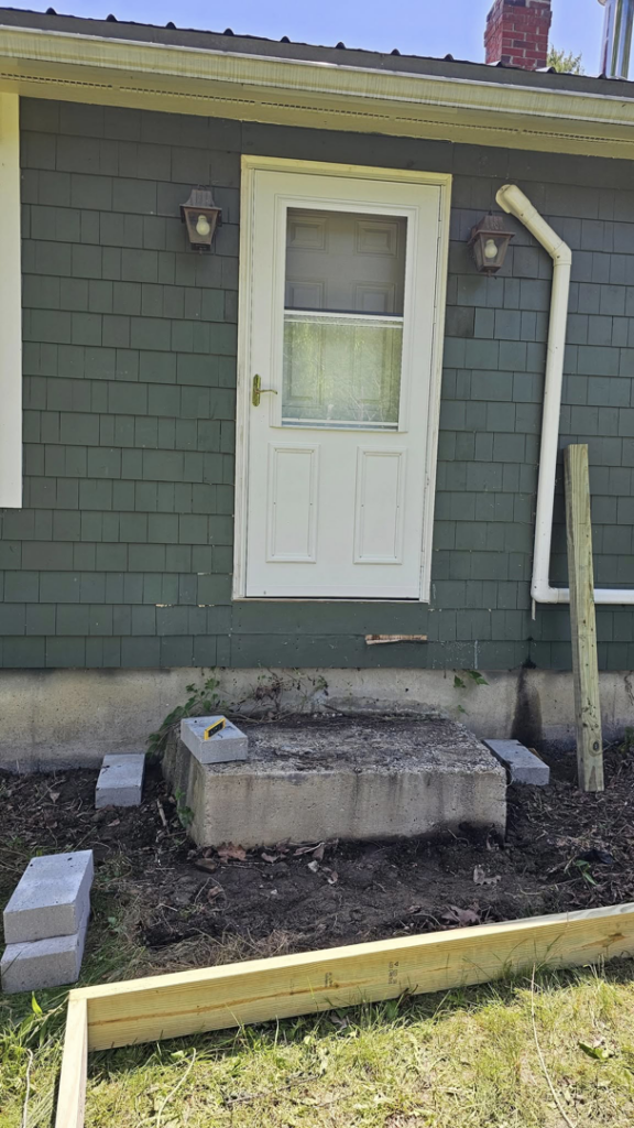 The area outside a house prepared for new deck construction by Goulds Family Property Management and Handyman Services in Searsport, ME.