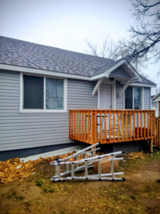 New wooden deck construction and siding installation on a house by Investment Handyman Services in Pocatello, ID