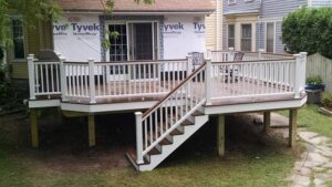A newly installed wooden deck with white railings and stairs by Four Seasons Building & Remodeling in Mauldin, SC.