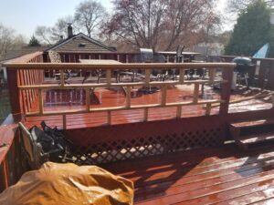 A wooden deck with new railing sections being installed or repaired by Excalibur Home Services in Council Bluffs, IA.